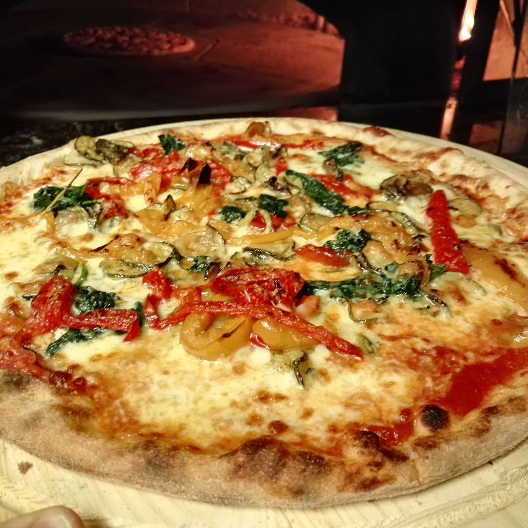 Pizza alle verdure appena sfornata dal forno a legna