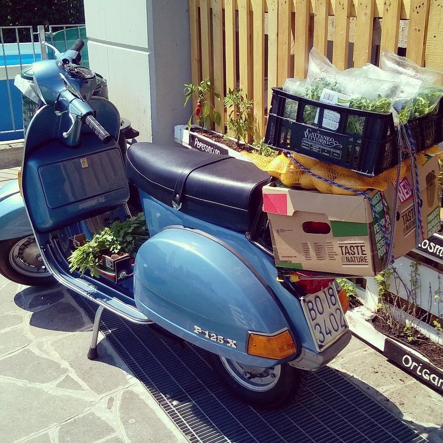 Vespa d'epoca carica di cassette di verdure fresche